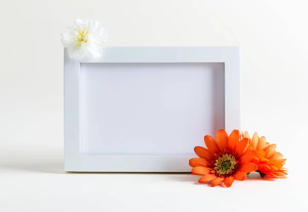 Prázdné bílý fotorámeček s květinami — Stock fotografie
