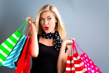 Alışveriş torbaları tutan mutlu genç kadın.