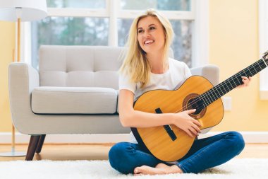 Gitar çalan genç bir kadın.