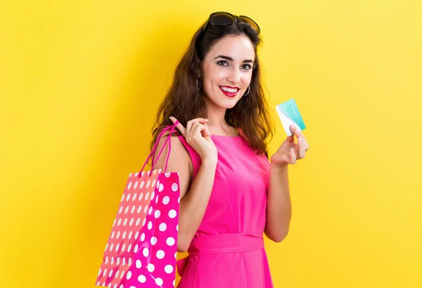 Woman holding a credit card and a shopping bag — Stock Photo, Image