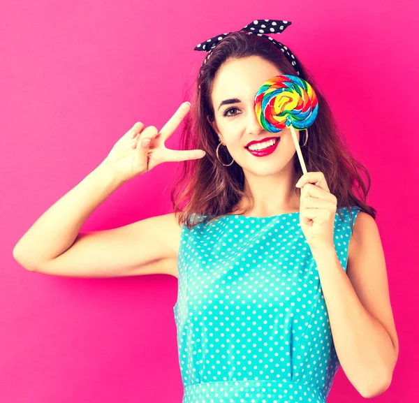 Mujer joven sosteniendo una piruleta — Foto de Stock