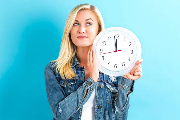 महिला घड़ी पकड़ रही है लगभग 12 दिखा रही है — स्टॉक फ़ोटो, इमेज