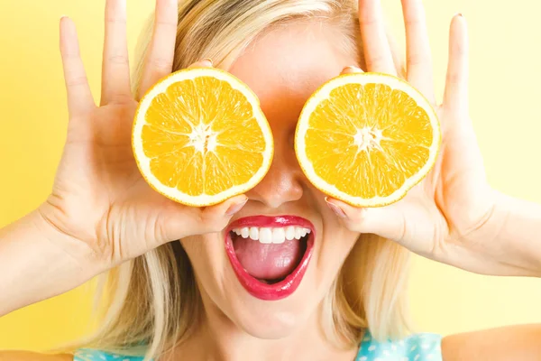 Portakal yarım tutan mutlu genç kadın