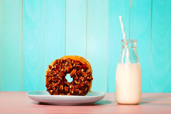 Donut met melk op een pastel achtergrond — Stockfoto