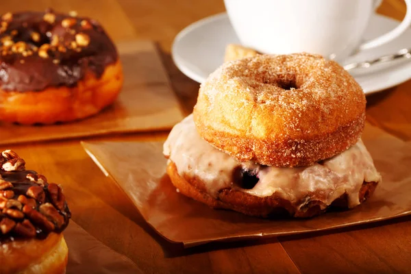 Donuts mit Kaffee auf rustikalem Holzgrund — Stockfoto