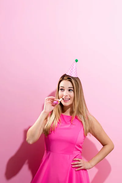 Woman in party hat with noisemaker — Stock Photo, Image