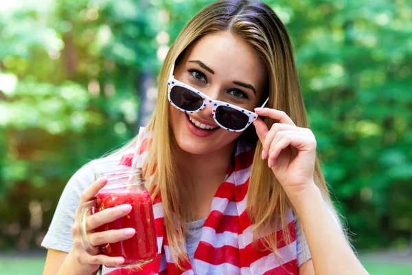 Glückliche Frau trinkt am 4. Juli draußen einen Smoothie — Stockfoto