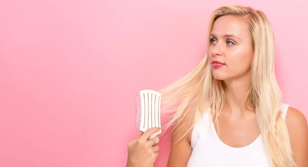 Bella donna che tiene una spazzola per capelli — Foto Stock