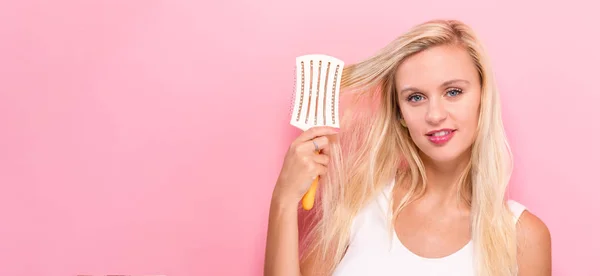 Mulher bonita segurando uma escova de cabelo — Fotografia de Stock