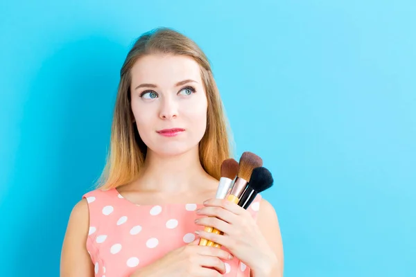 Mujer sosteniendo cepillos de maquillaje — Foto de Stock