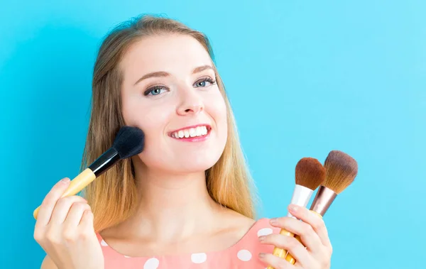 Mujer sosteniendo cepillos de maquillaje — Foto de Stock