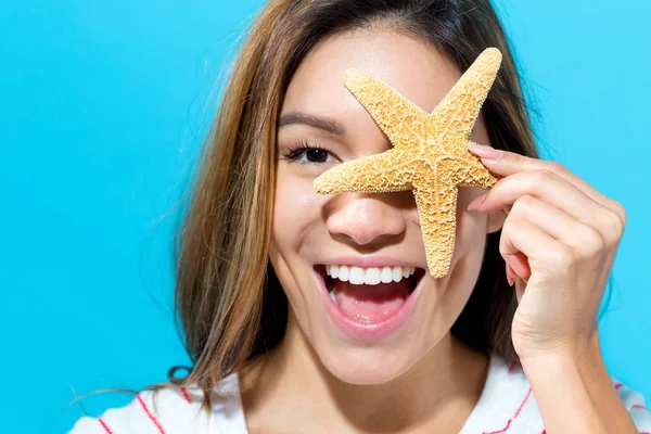 Bir deniz yıldızı ile mutlu kadın — Stok fotoğraf