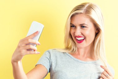 Genç bir kadın selfie çekiyor. 