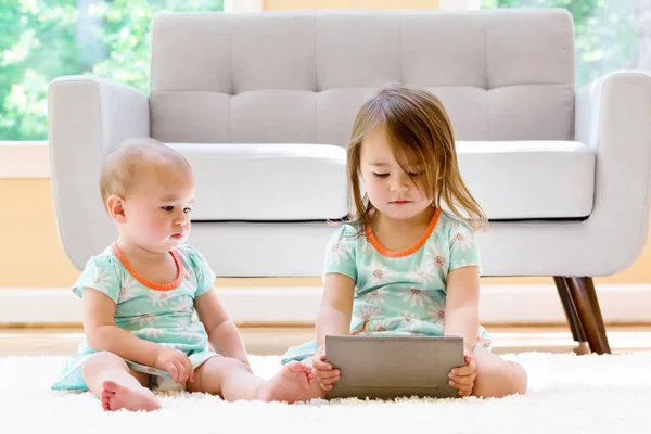 Zusters kijken naar een tablet-pc — Stockfoto