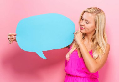 Elinde konuşma balonu tutan genç bir kadın. 