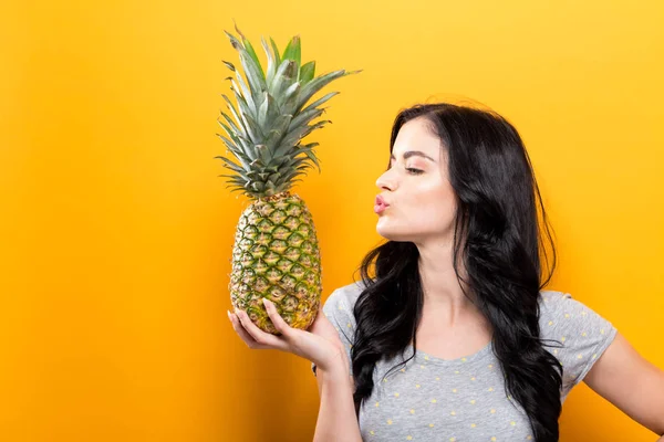 Šťastná mladá žena držící ananas — Stock fotografie