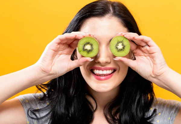 Jovem feliz segurando kiwis — Fotografia de Stock