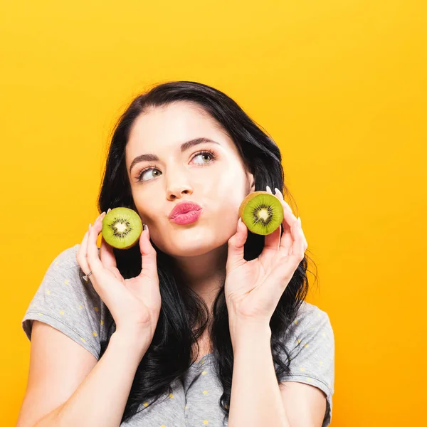 Jovem feliz segurando kiwis — Fotografia de Stock