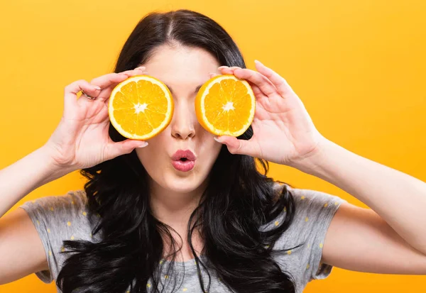 Mutlu genç kadın holding portakal 