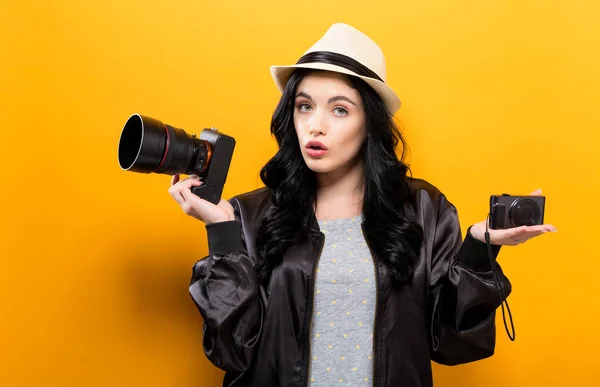 Junge Frau vergleicht professionelle und Kompaktkameras — Stockfoto