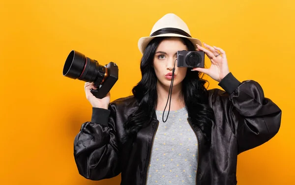 Giovane donna confrontando macchine fotografiche professionali e compatte — Foto Stock