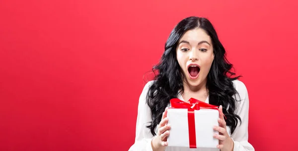 Joyeux jeune femme tenant une boîte cadeau — Photo