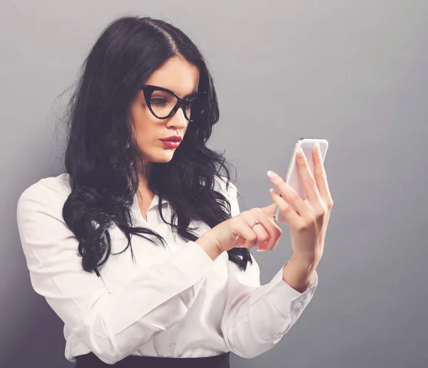 Jovem mulher usando seu telefone — Fotografia de Stock