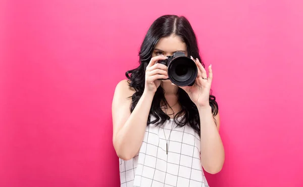 Młoda kobieta trzyma aparat fotograficzny — Zdjęcie stockowe