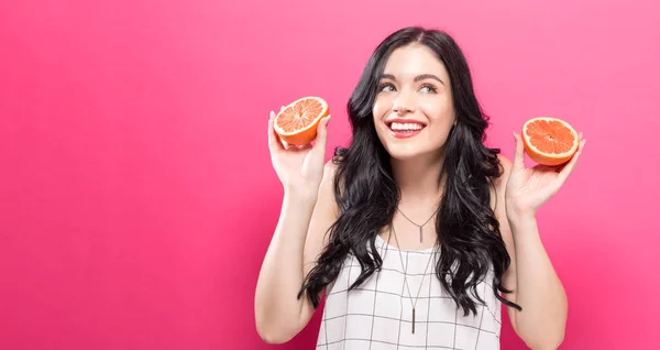 Glückliche junge Frau mit Orangen in der Hand — Stockfoto