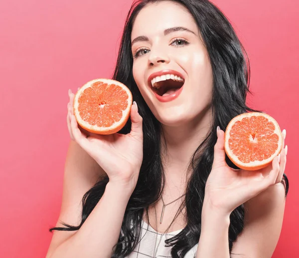 Mutlu genç kadın holding portakal 