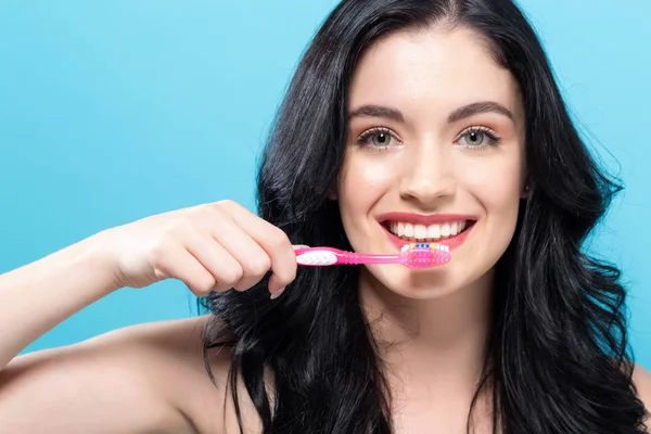 Mujer joven sosteniendo un cepillo de dientes — Foto de Stock