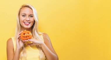 Balkabağı tutan genç bir kadın.