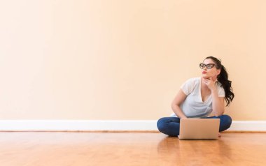 Dizüstü bilgisayarını kullanan genç bir kadın.