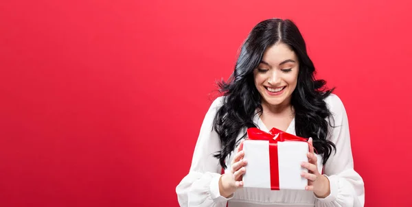 Ευτυχισμένη νεαρή γυναίκα που κρατάει ένα κουτί δώρου — Φωτογραφία Αρχείου