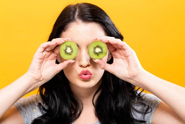 Jovem feliz segurando kiwis — Fotografia de Stock