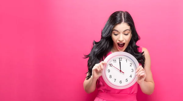 Mujer sosteniendo reloj mostrando casi 12 — Foto de Stock