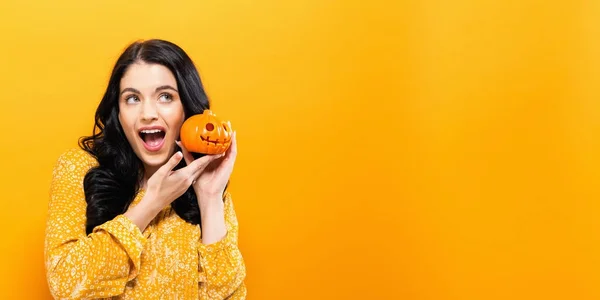 Mujer joven sosteniendo una calabaza — Foto de Stock