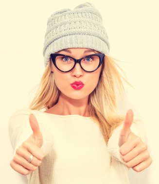 Mutlu genç bir kadın başparmağını kaldırıyor.