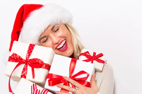 Mulher com chapéu de santa segurando caixas de presente — Fotografia de Stock