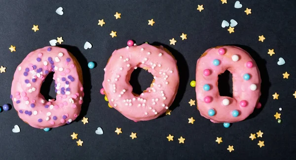Kleurrijke geglazuurde donuts op een zwarte achtergrond — Stockfoto