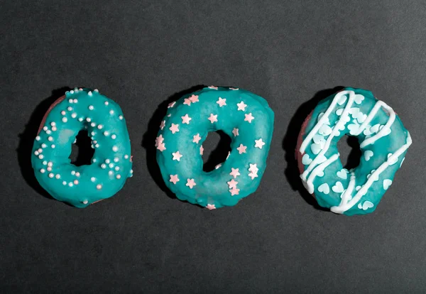 Kleurrijke geglazuurde donuts op een zwarte achtergrond — Stockfoto