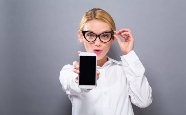 Bir cep telefonu tutan genç kadın