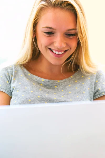 Mladá žena pomocí její laptop v na svém gauči — Stock fotografie