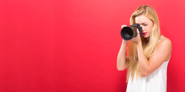 Jeune femme comparant caméra professionnelle — Photo