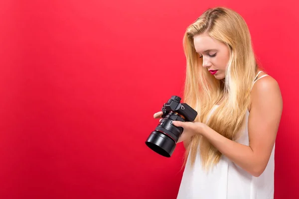 Mujer joven comparando cámara profesional — Foto de Stock