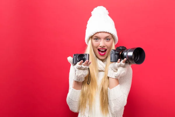 Jeune femme comparant caméras professionnelles et compactes — Photo