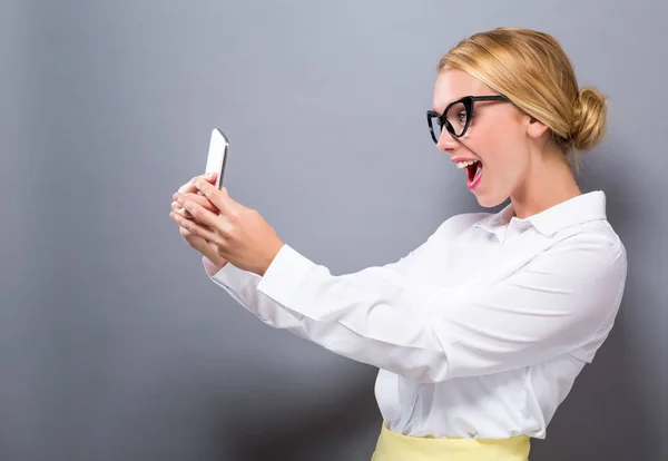 Ung kvinna som använder sin telefon — Stockfoto
