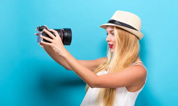 Jeune femme comparant caméra professionnelle — Photo
