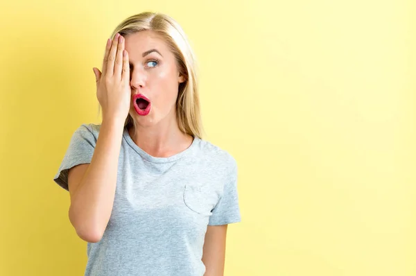 Feliz joven mujer cubriendo un ojo con su mano — Foto de Stock