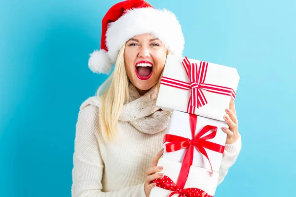 Mulher com chapéu de santa segurando caixas de presente — Fotografia de Stock